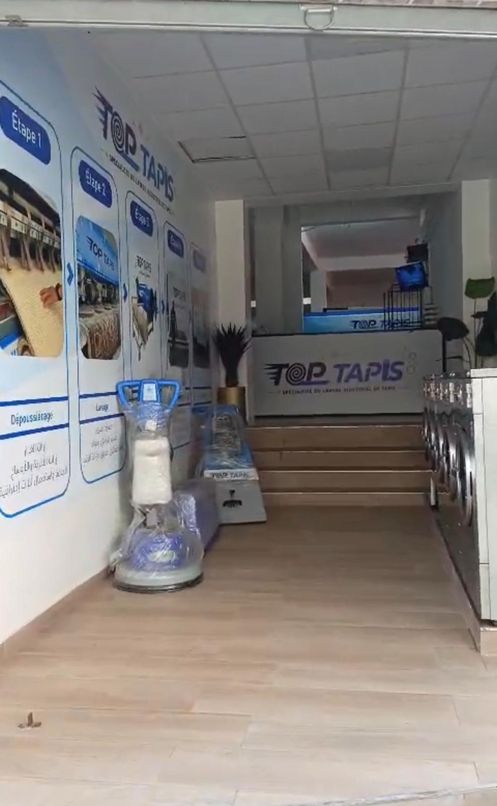 Entrée de la boutique TOP TAPIS avec le comptoir d’accueil et les équipements